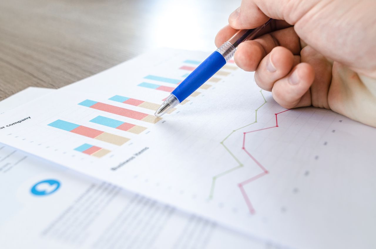 Printed charts and business reports being reviewed at a desk